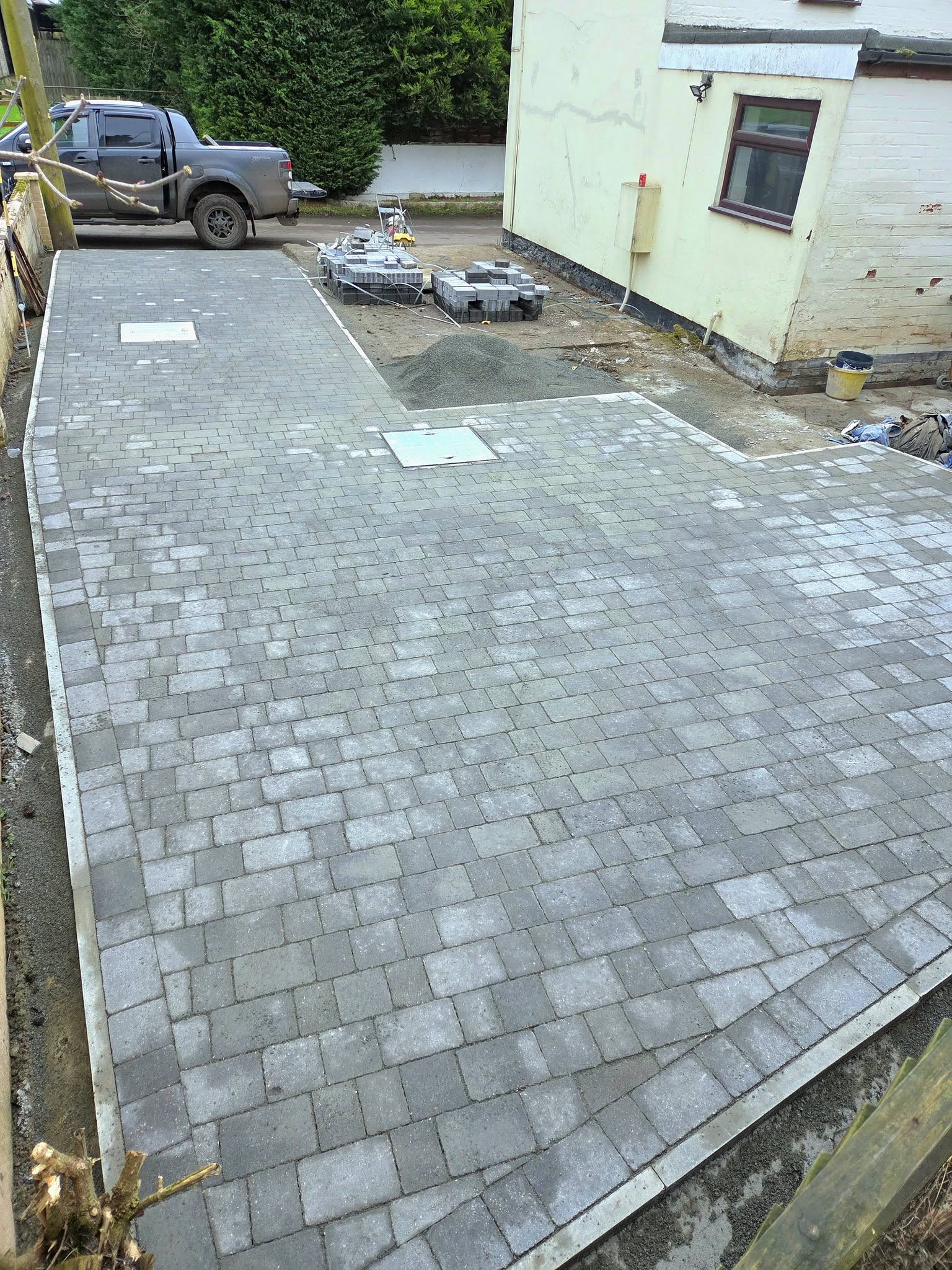 Block paved driveway with charcoal blocks on permeable granite sub-base