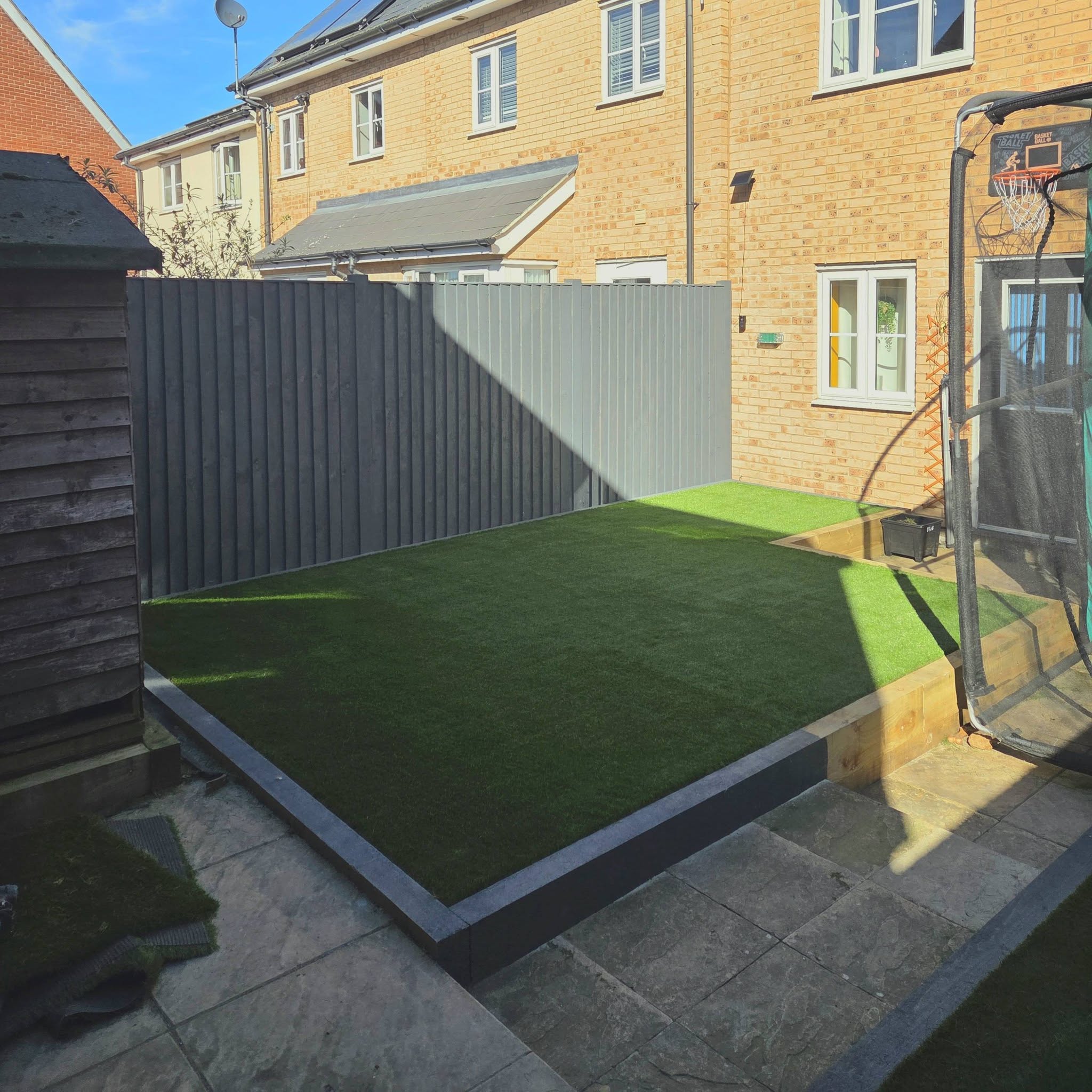 Thetford garden transformation with artificial grass, fencing and sleeper beds