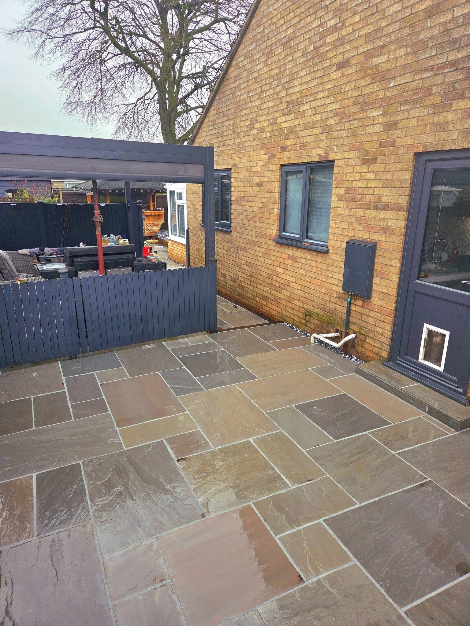 Wymondham grey sandstone patio with black ice stone border